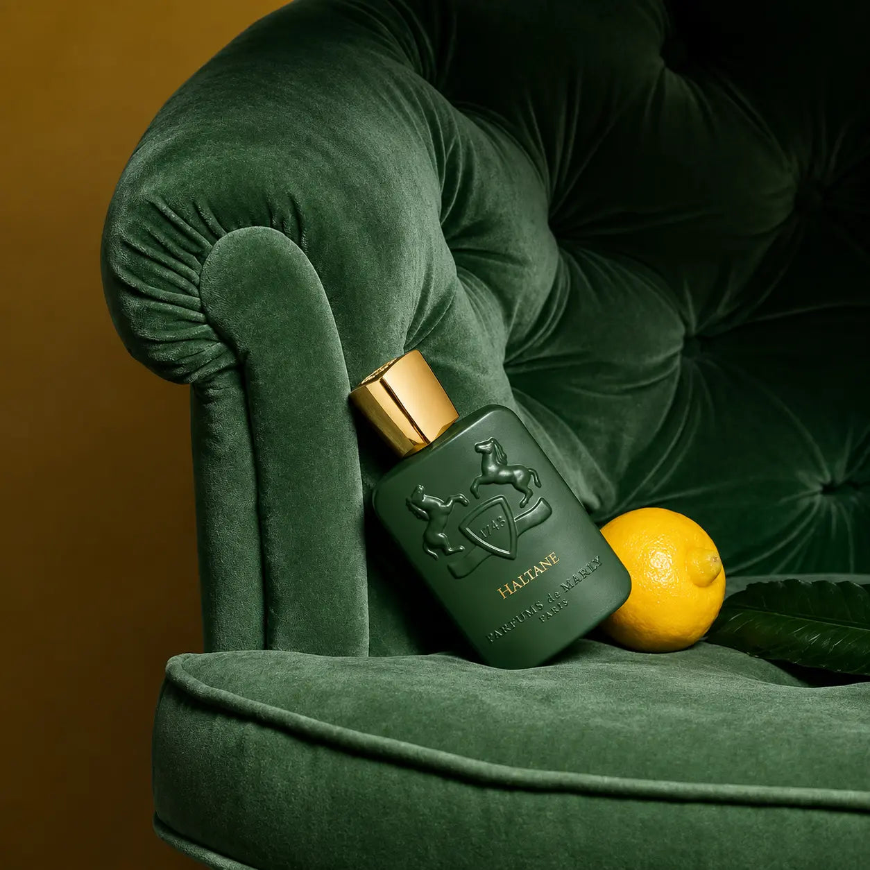 Haltane by Parfums de Marly eau de parfum bottle on green velvet armchair with fresh lemon, citrus woody fragrance for men
