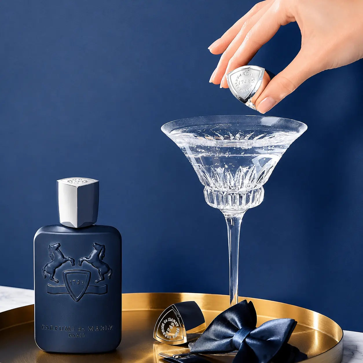 Parfums de Marly Layton Blue perfume Bottle of L'Herbier de Marly perfume with a martini glass and cocktail ingredients on a blue background
