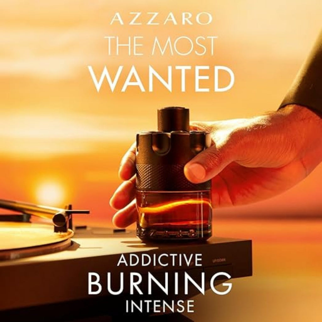 Hand holding a bottle of Azzaro cologne with sunset background